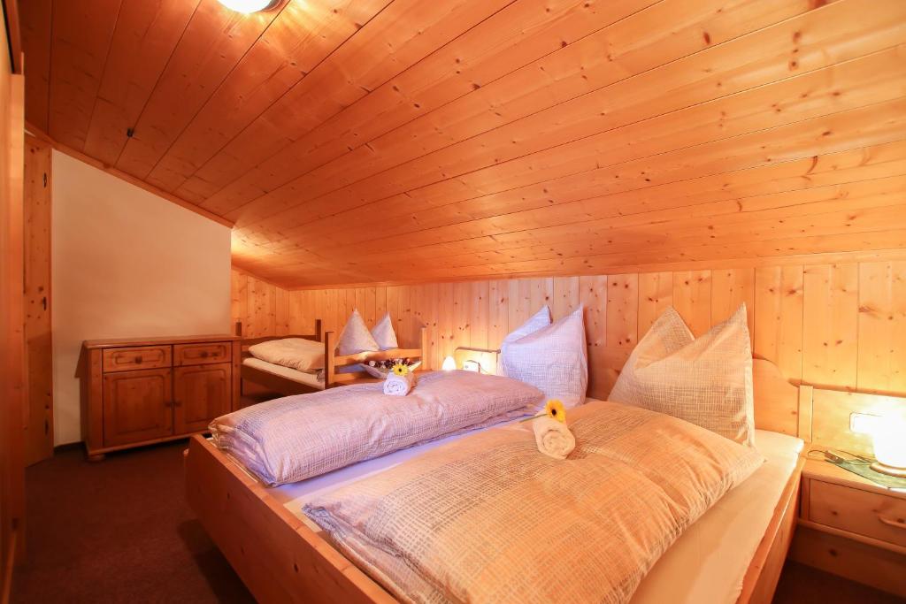 萨菲登安斯泰内嫩米尔Haus Eder的木制客房内的一间卧室配有一张大床