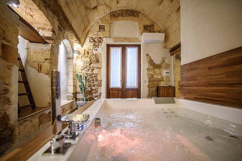 梅萨涅Sacratum B&B Suite Spa的一间大浴室,内设一个大浴缸