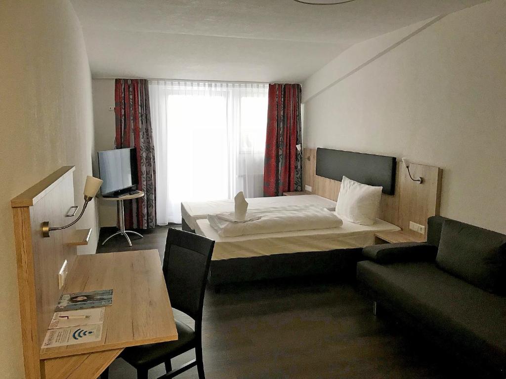 LangenbeutingenKüffner Hof的酒店客房配有床、沙发和桌子。
