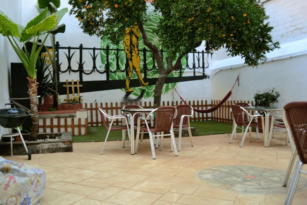 塔拉戈纳塔拉戈纳旅舍的庭院配有桌椅和一棵树