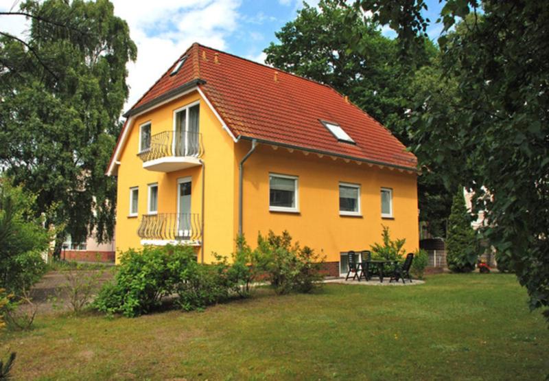 巴贝Ferienapp Dr Beate Gurle Und Dr的院子里有红色屋顶的黄色房子