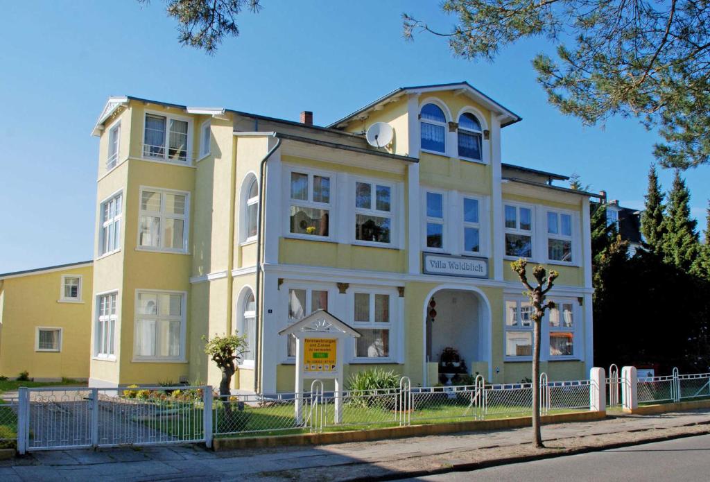 巴贝Villa Waldblick in Baabe的街道边的黄色建筑