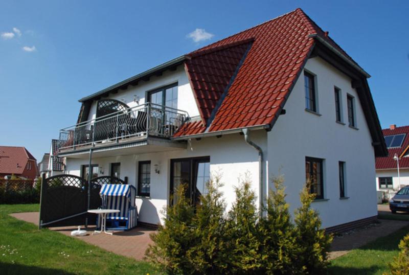 巴贝Ferienhaus Alt_Baabe的白色房子,有红色屋顶