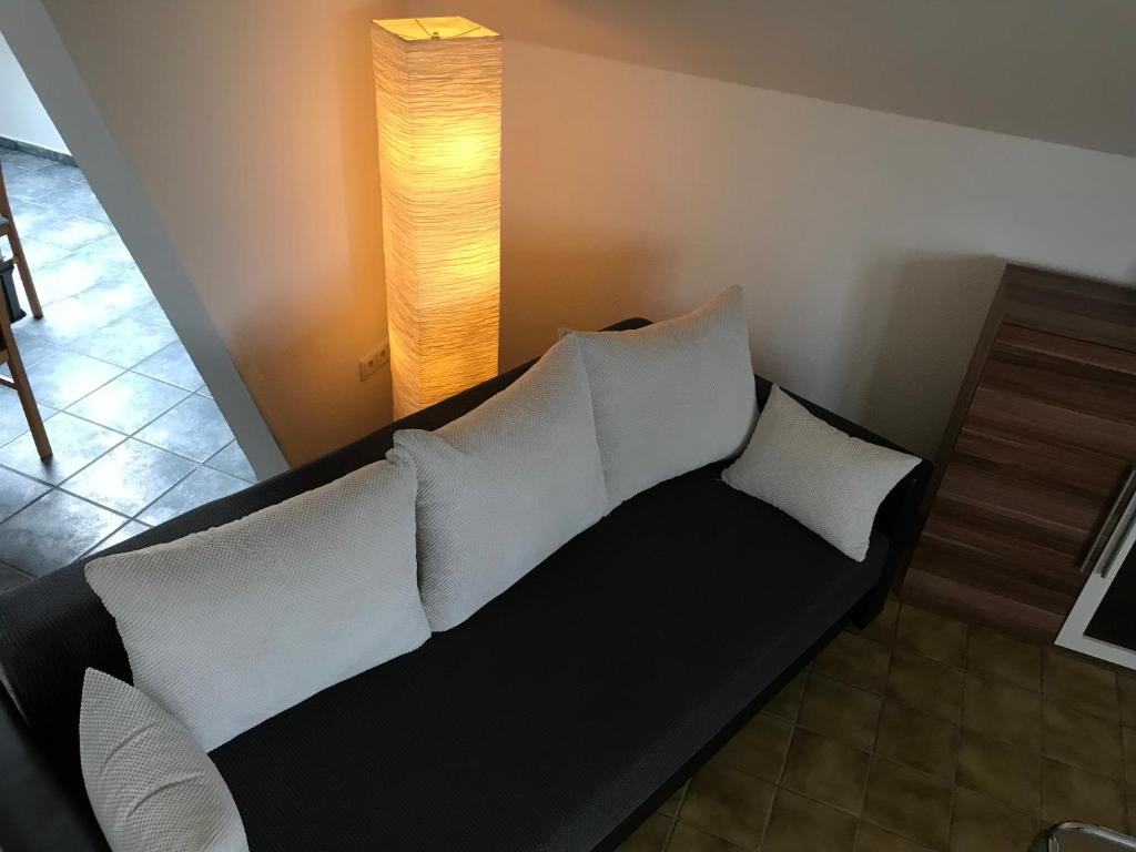 勒讷Apartment Am Sudbach的客房内的黑色沙发,配有白色枕头