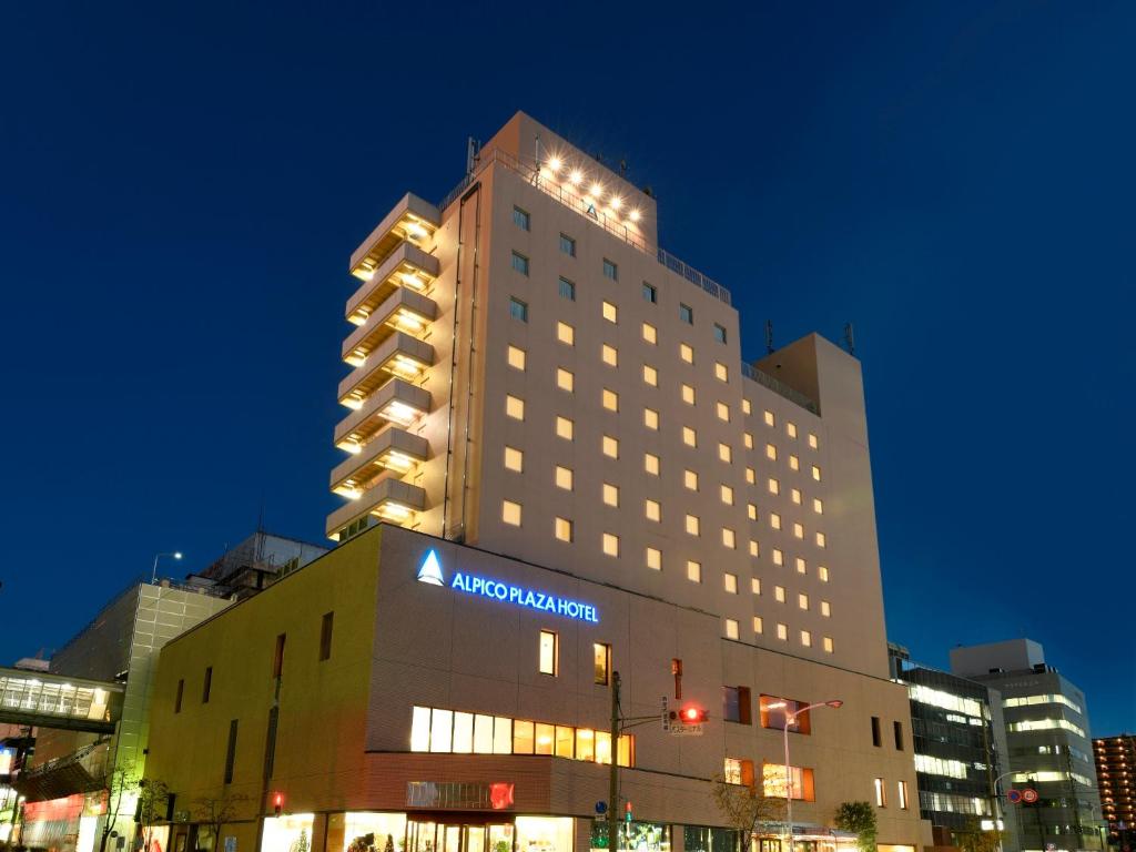 松本阿尔皮科广场酒店的一座大建筑,上面有Aania标志