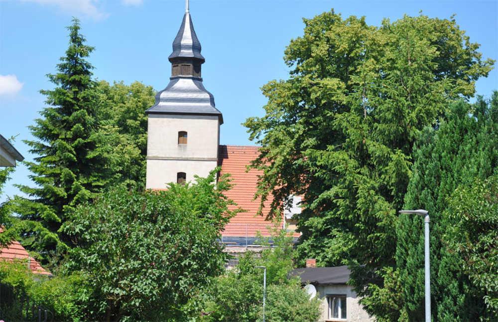 奔驰Ferienhaus Benz USE 1641的教堂陡峭的顶部,有树木