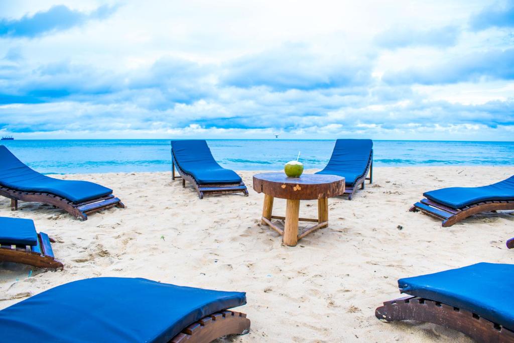 卡尔皮蒂耶欧美莎海滩酒店的海滩上的一组椅子和一张桌子