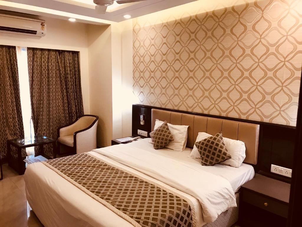 浦那Hotel Kohinoor Executive的卧室配有一张带白色床单和枕头的大床。