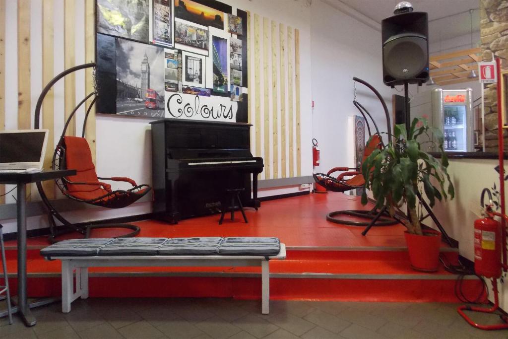 米兰色彩旅舍的一间设有钢琴、桌子和椅子的客房
