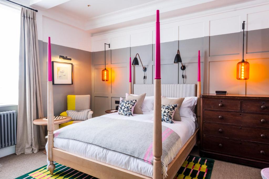 绍斯沃尔德天鹅大酒店的一间卧室配有四柱床和梳妆台