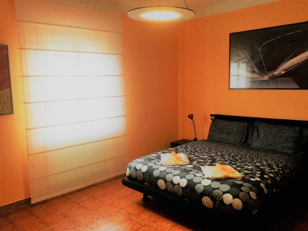 圣朱利亚诺-泰尔梅Sabry apartment的一间卧室拥有橙色的墙壁,床上有水果