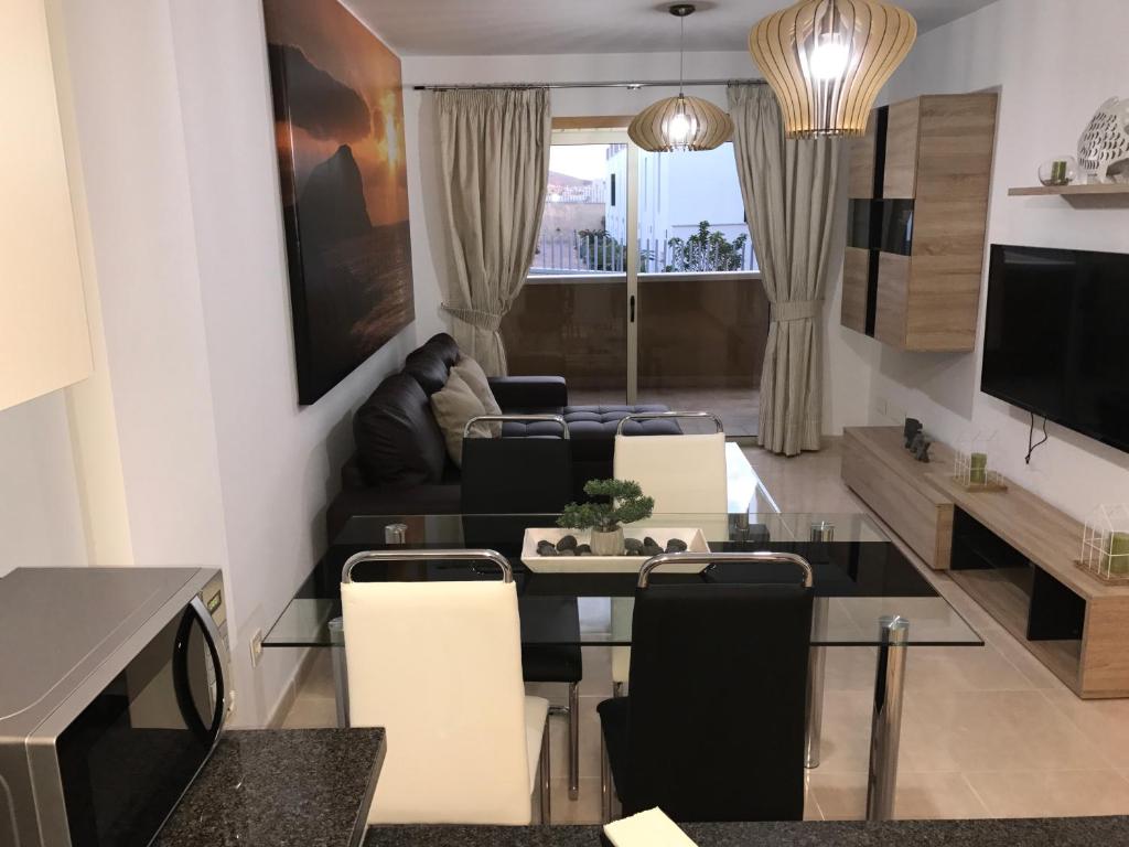 厄尔梅达诺La Perla Medano 2的客厅配有桌椅和电视。