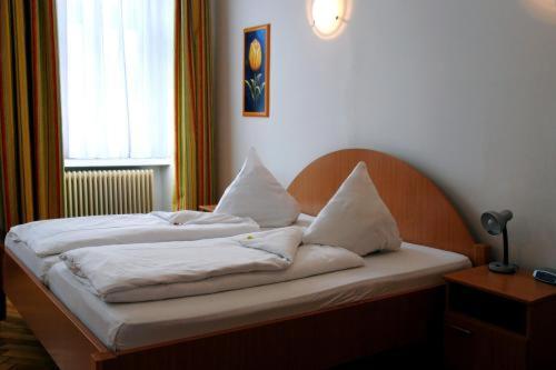 维也纳祖玛普拉特200米套房酒店的一张带白色床单和枕头的床