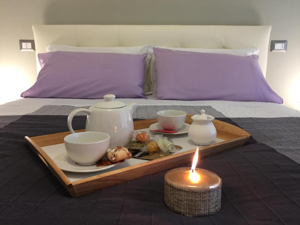 罗马罗马甜蜜之家公寓的床上的带茶具和蜡烛的托盘