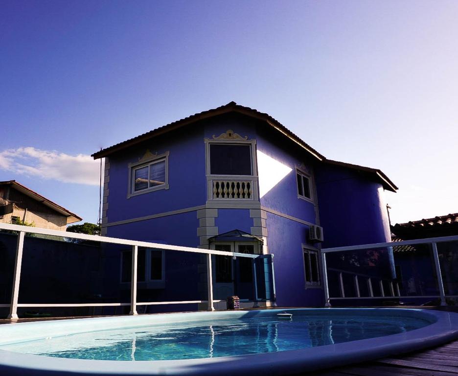 弗洛里亚诺波利斯Suite Queen D'Arte的蓝色的房子,前面设有一个游泳池