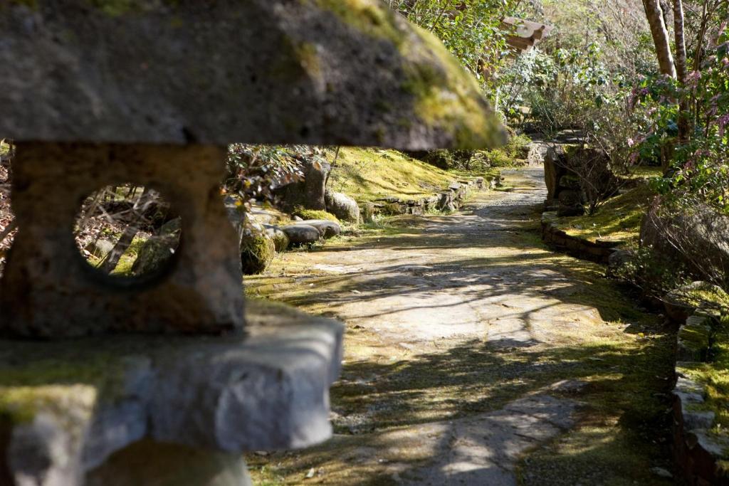 日田市琴平恩宾馆的花园中种有树木和草地的石头路径
