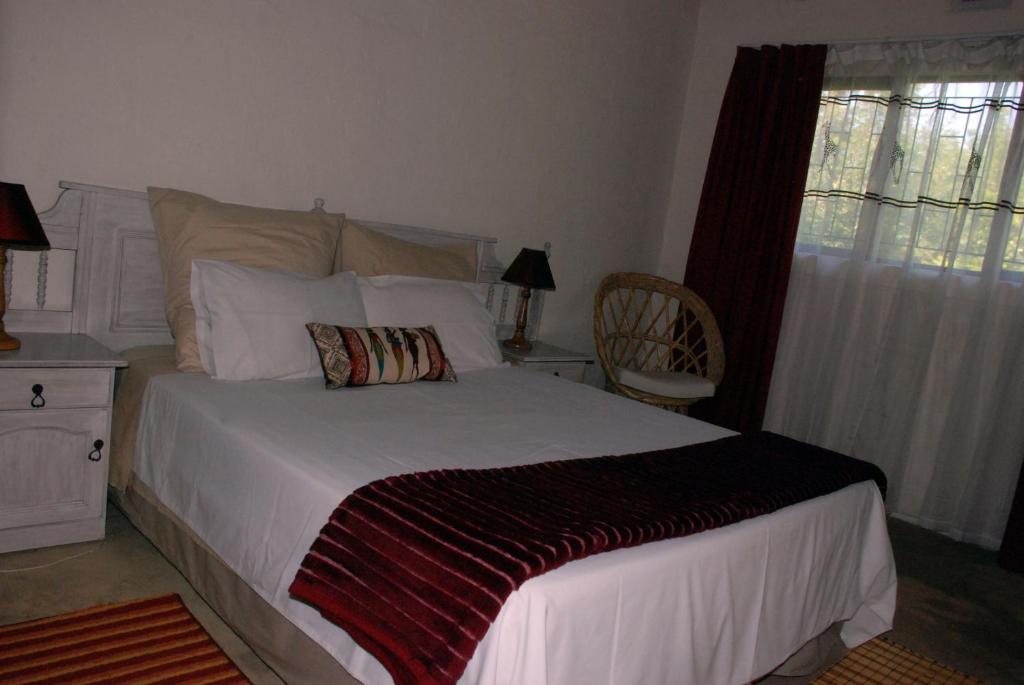 索德瓦纳湾Toad Tree Cabins的卧室配有床、椅子和窗户。