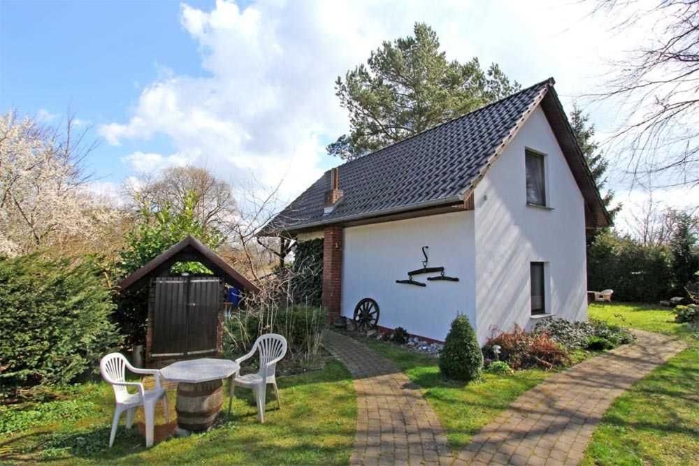 克劳斯多夫Ferienwohnungen Klausdorf FDZ 360的院子里的白色房子,配有桌椅