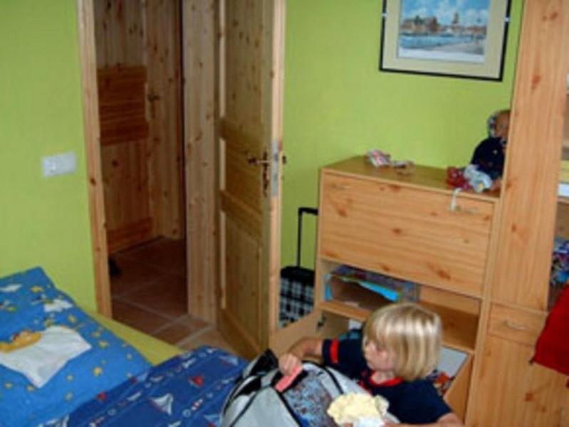 卡尔斯哈根Ferienwohnungen Karlshagen USE 2060的卧室里的小孩,背着背包