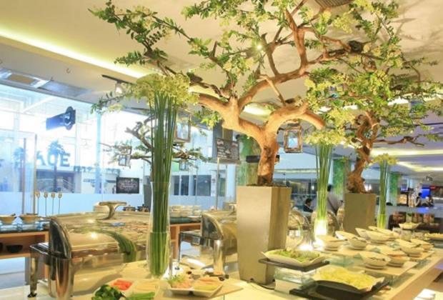 马尼拉ACE套房酒店 的一间餐厅,餐桌上放着树木和盘子