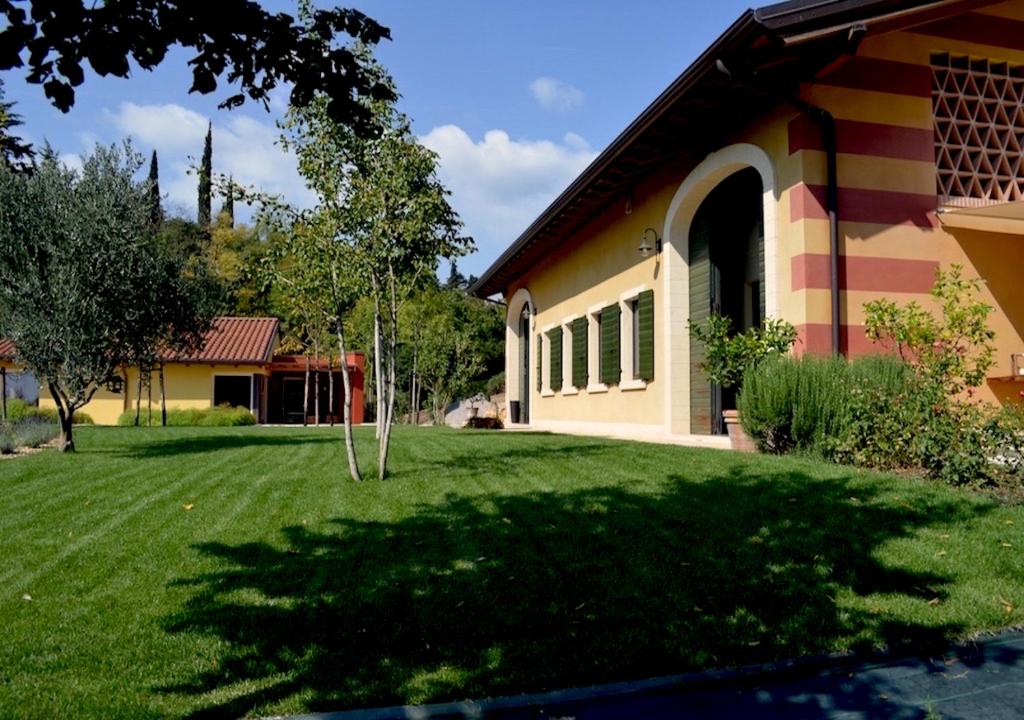 维罗纳Agriturismo Sommavalle的一座房子,旁边是一座绿色庭院