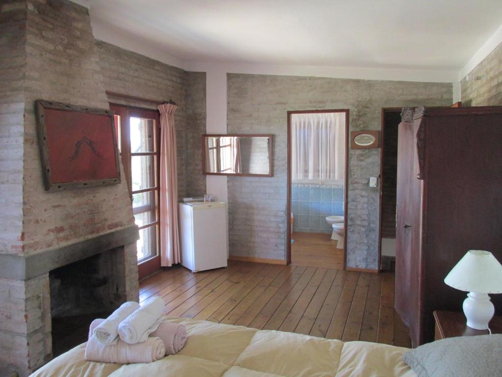 何塞伊格纳西奥Je Nous Casa的一间带壁炉和床的卧室以及一间浴室。
