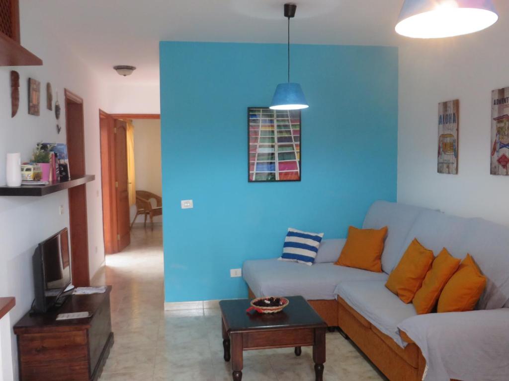 法马拉Coqueto apartamento的带沙发和蓝色墙壁的客厅