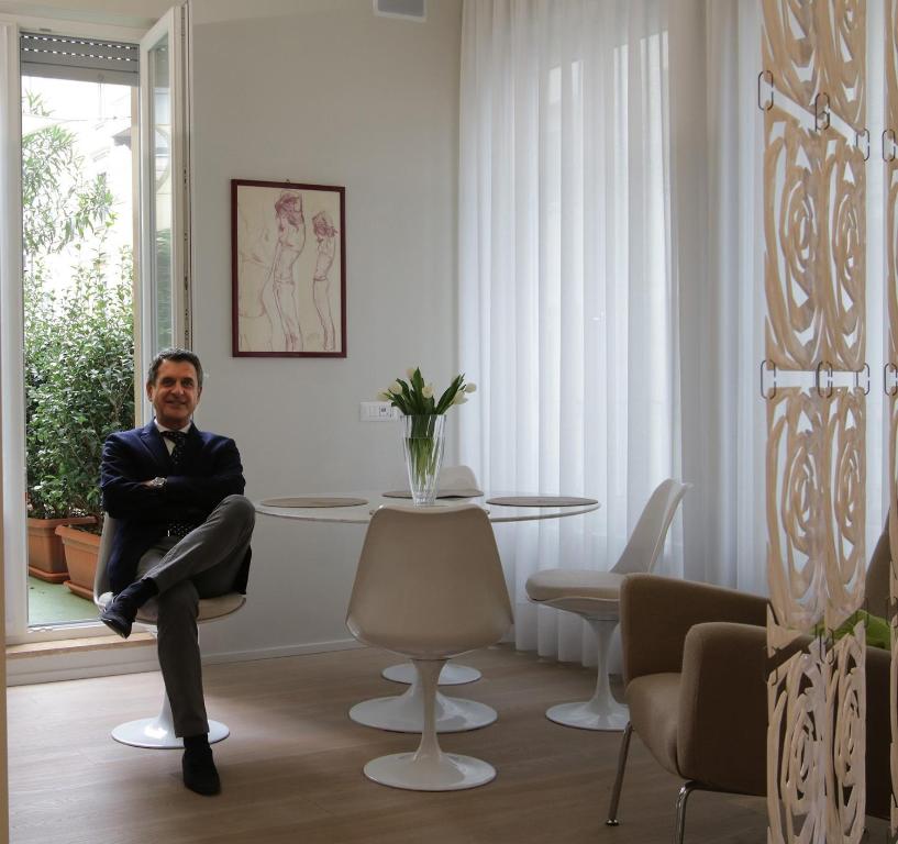 米兰Milano Porta Venezia Suite Centro的坐在桌子旁椅子上的人