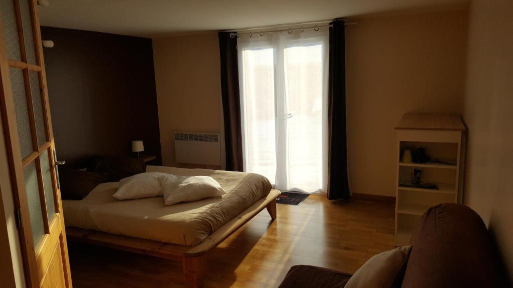 EchallonChambre d hôtes du lac的一间卧室设有一张床和一个大窗户