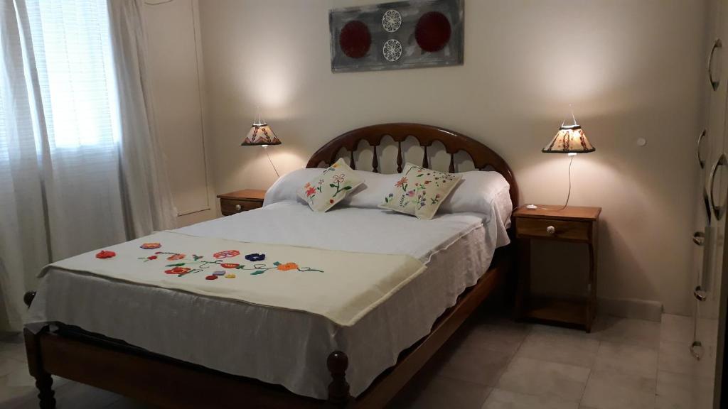 圣米格尔·德·图库玛Apart Polonia的一间卧室配有一张带2个床头柜和2盏灯的床。