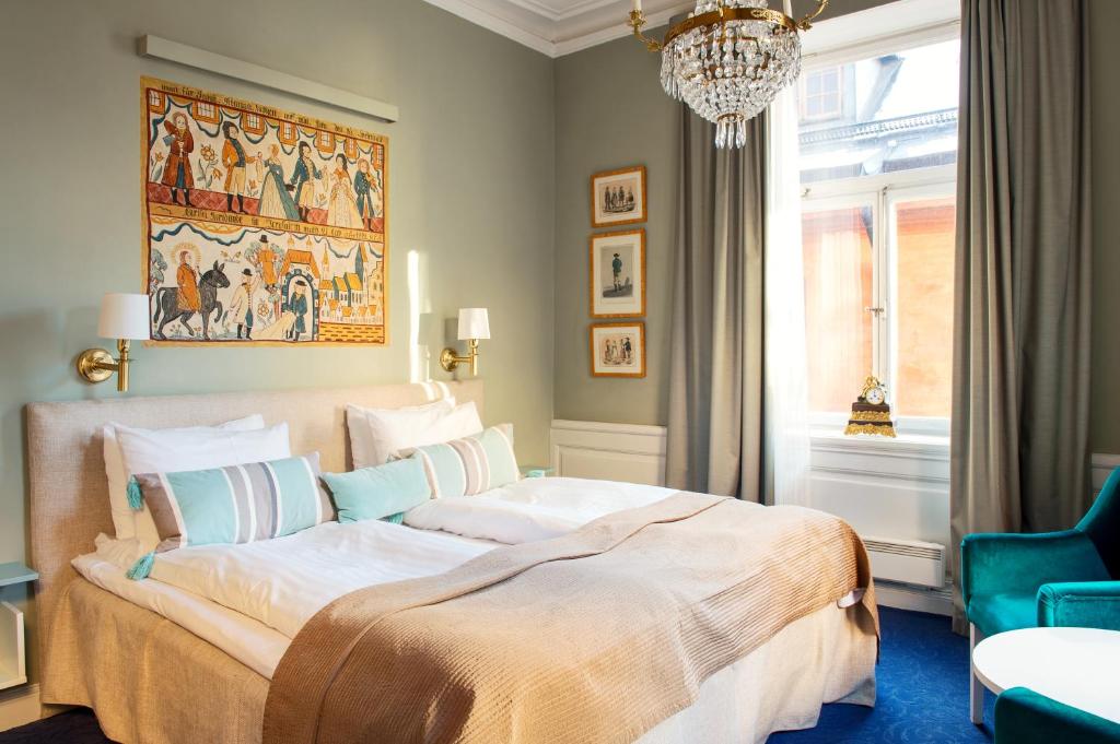 斯德哥尔摩Lady Hamilton Hotel的一间卧室配有一张大床和一个吊灯。