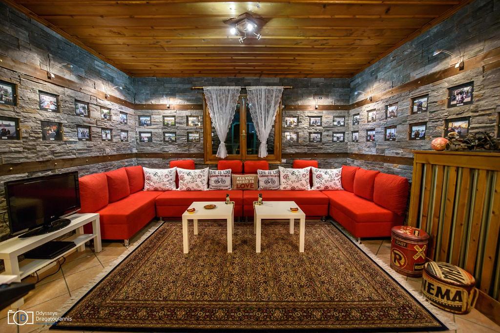 特里卡拉Traditional Guesthouse的客厅配有红色沙发和电视