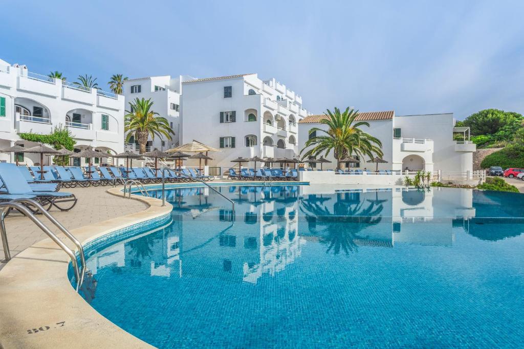 阿雷纳尔登卡斯特尔钻石度假村白沙海滩俱乐部酒店的大楼前的蓝色海水游泳池