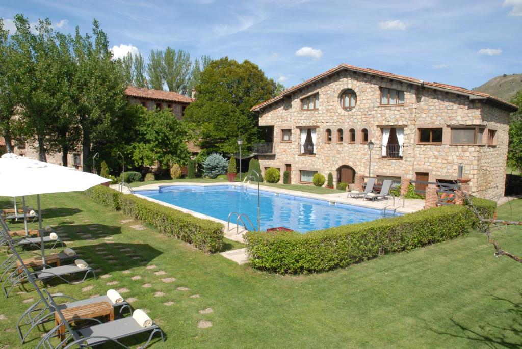 锡古恩萨Molino de Alcuneza Relais & Châteaux的享有带游泳池的石屋的外部景色