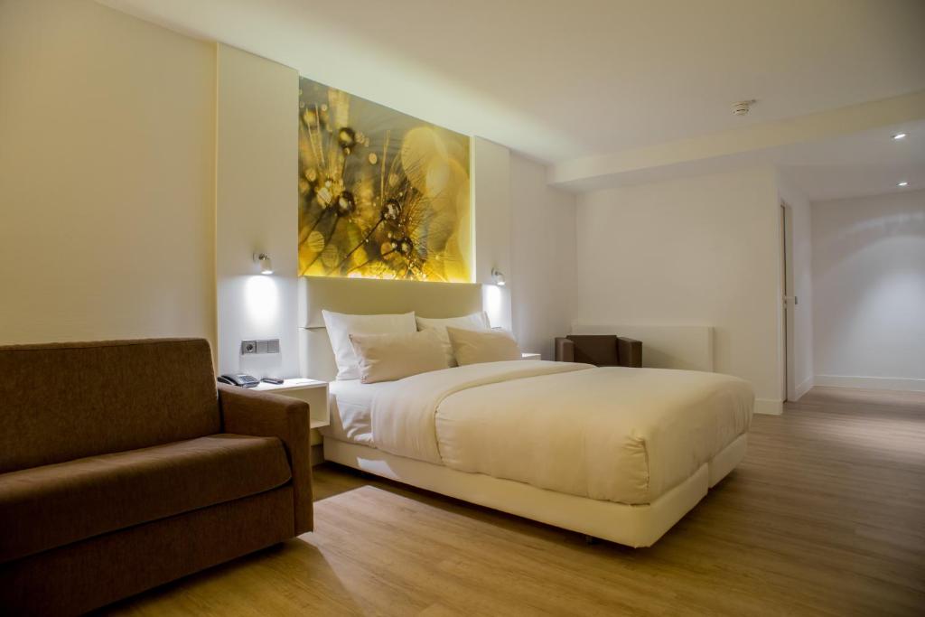 布拉河畔的海登海姆海登海姆品味酒店的卧室配有白色的床和沙发
