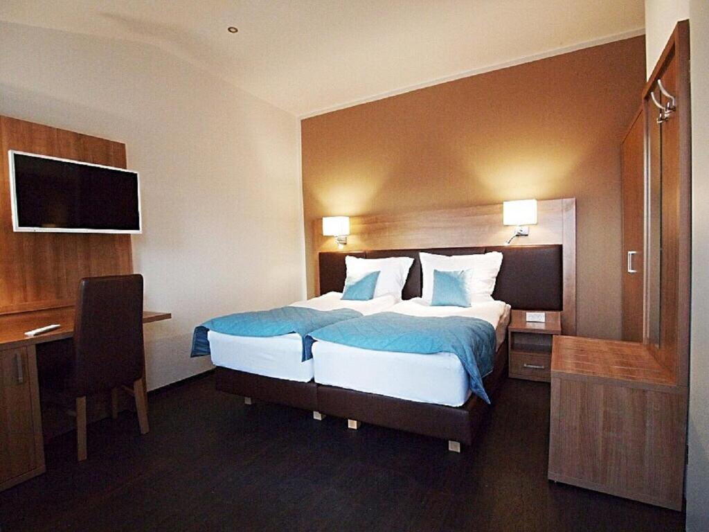 多鲁姆Sporthotel Dorum的酒店客房设有一张大床和一张书桌。