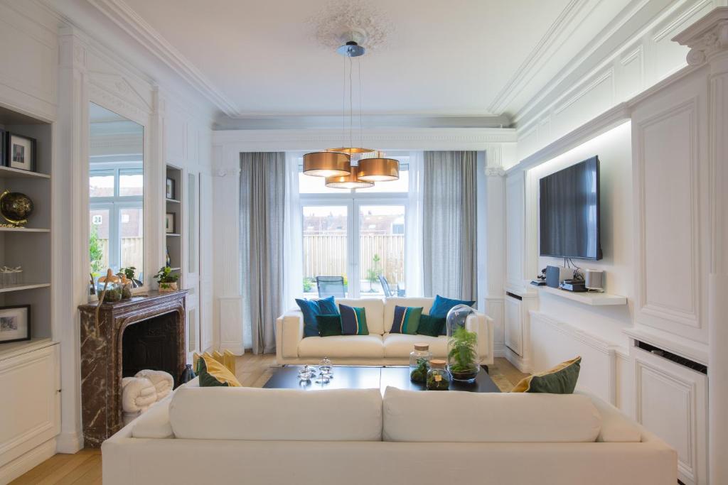 里尔Luxueux logement Bourgeois de 250 M2 climatisé的客厅配有2张白色沙发和壁炉