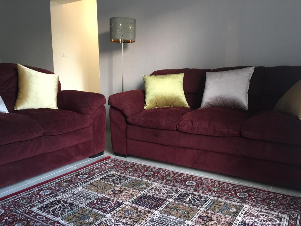 开罗Al-Rehab luxury apartment的客厅配有两张红色的沙发和地毯。