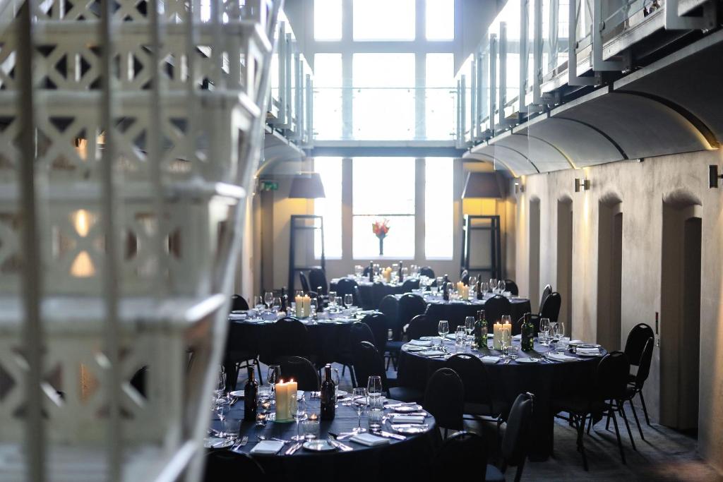 牛津马尔马逊牛津酒店的一间摆放着桌椅和蜡烛的房间