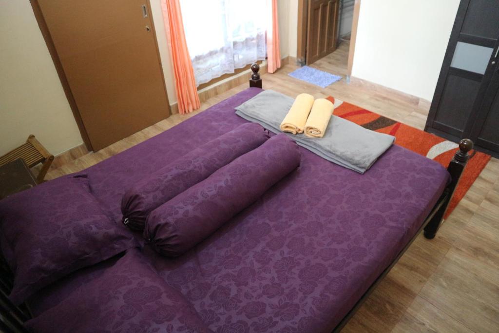 日惹肯巴尔住宿加早餐旅馆的一张紫色床,上面有两个枕头
