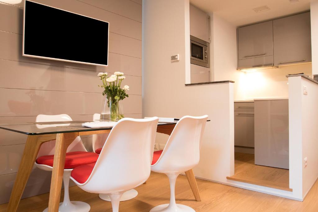 米兰Milano Repubblica Suite Centro的一间带桌椅和电视的用餐室