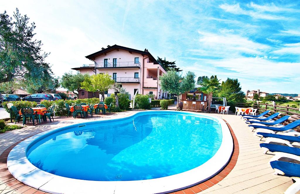 马内尔巴贝拉维斯塔住宅酒店的一个带椅子的游泳池和一个背景建筑