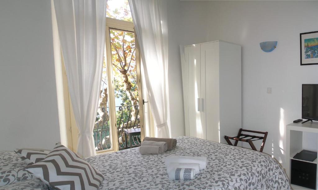 卢加诺卢加诺佛伦西酒店的白色的卧室设有床和窗户
