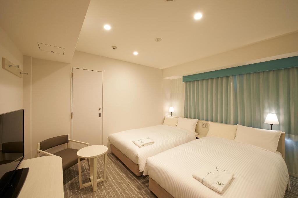 东京索特图斯弗雷撒银座三丁目经济型酒店的酒店客房配有两张床和一张书桌