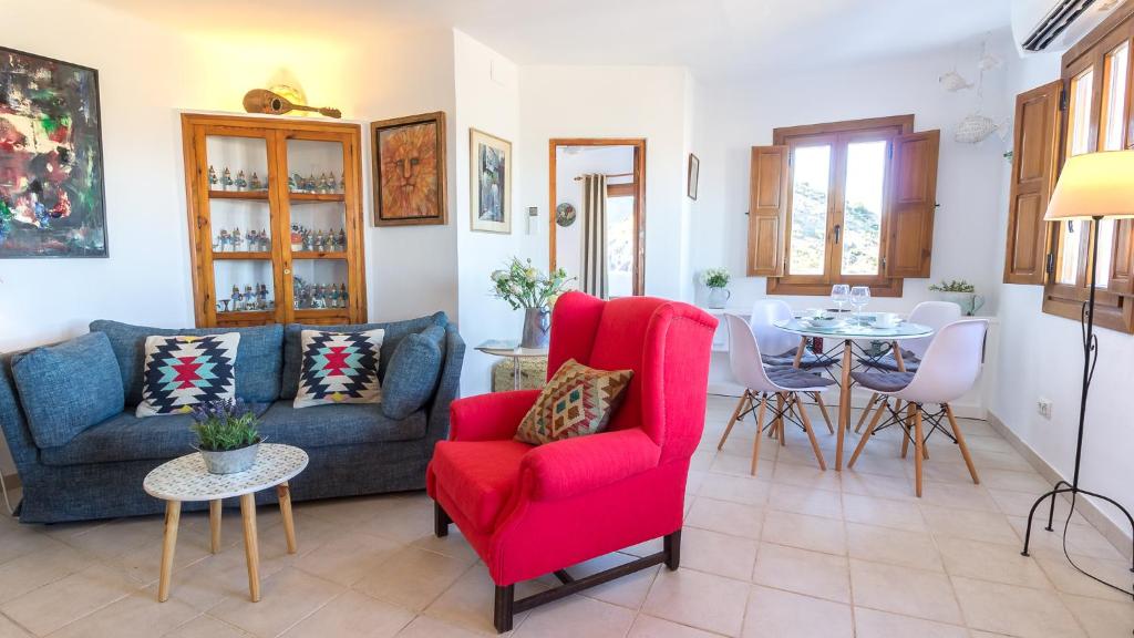 莫哈卡尔Casa Baja Mojacar Pueblo的客厅配有红色椅子和桌子