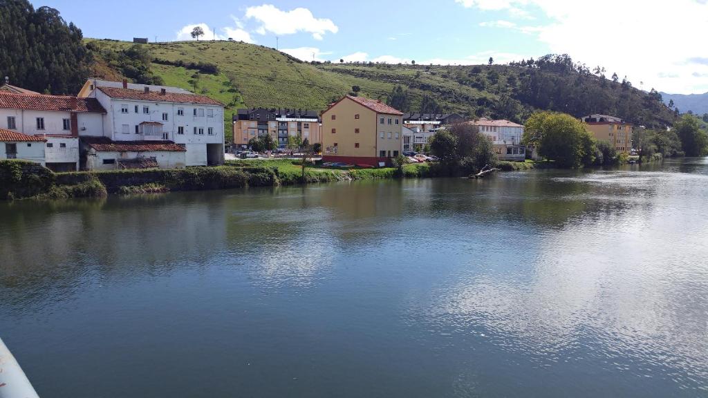 温克拉Apartamento Unquera - Cantabria的城镇中拥有房屋和建筑物的河流