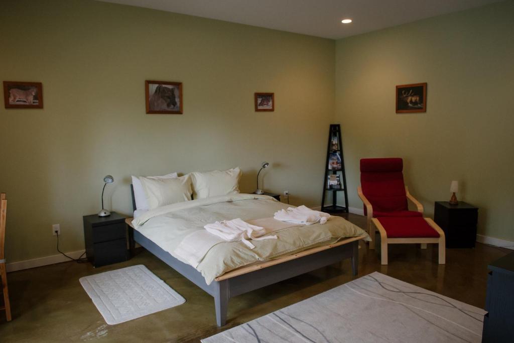 奥索尤斯芭格耐斯住宿加早餐酒店的一间卧室配有一张床和一张红色椅子