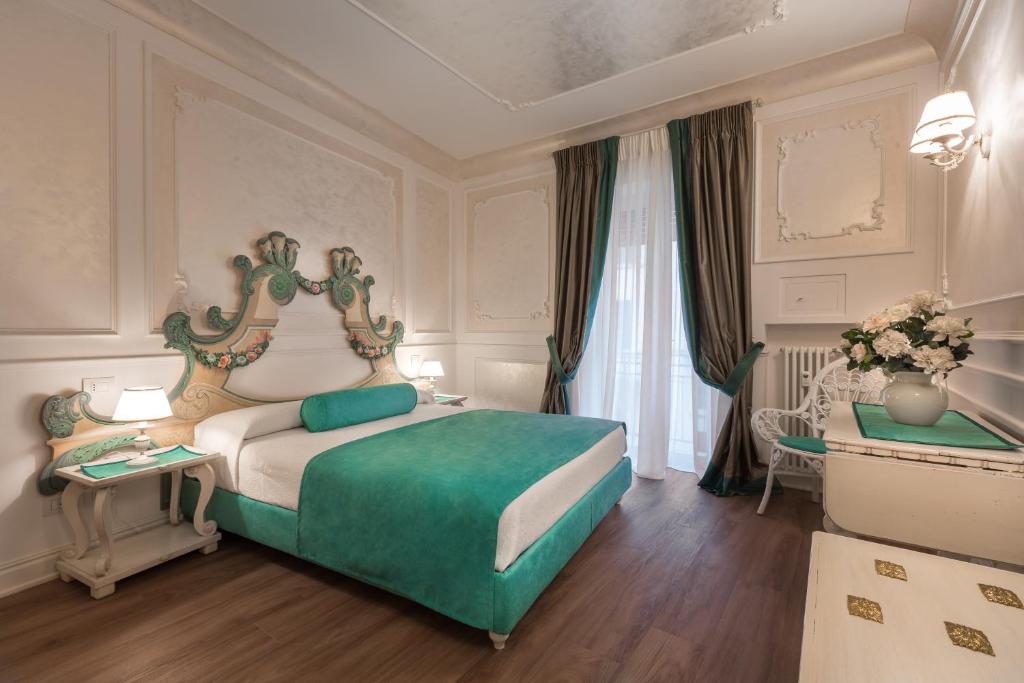维罗纳Guelphs Apartments的卧室设有绿色和白色的床和窗户。