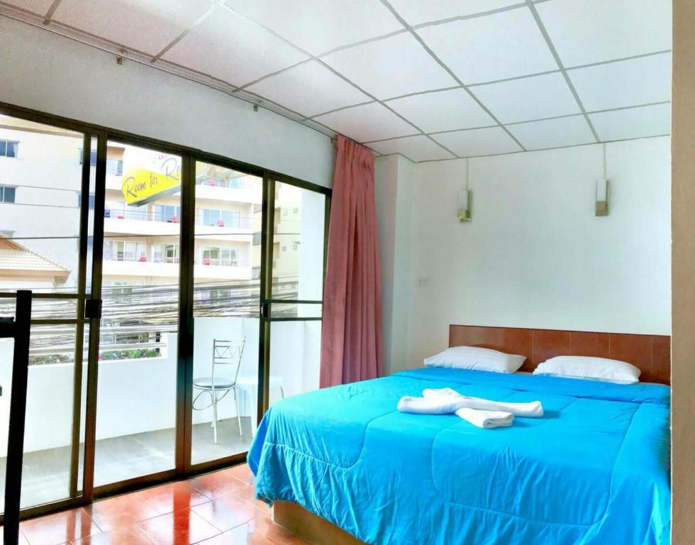 芭堤雅市中心玛丽伊之家及餐厅的一间卧室设有蓝色的床和一个阳台