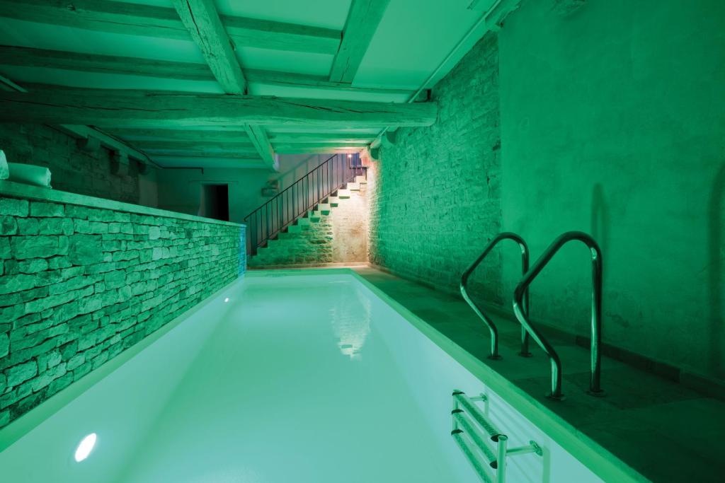博讷美资艾尔修道院酒店的浴室配有蓝色照明的浴缸
